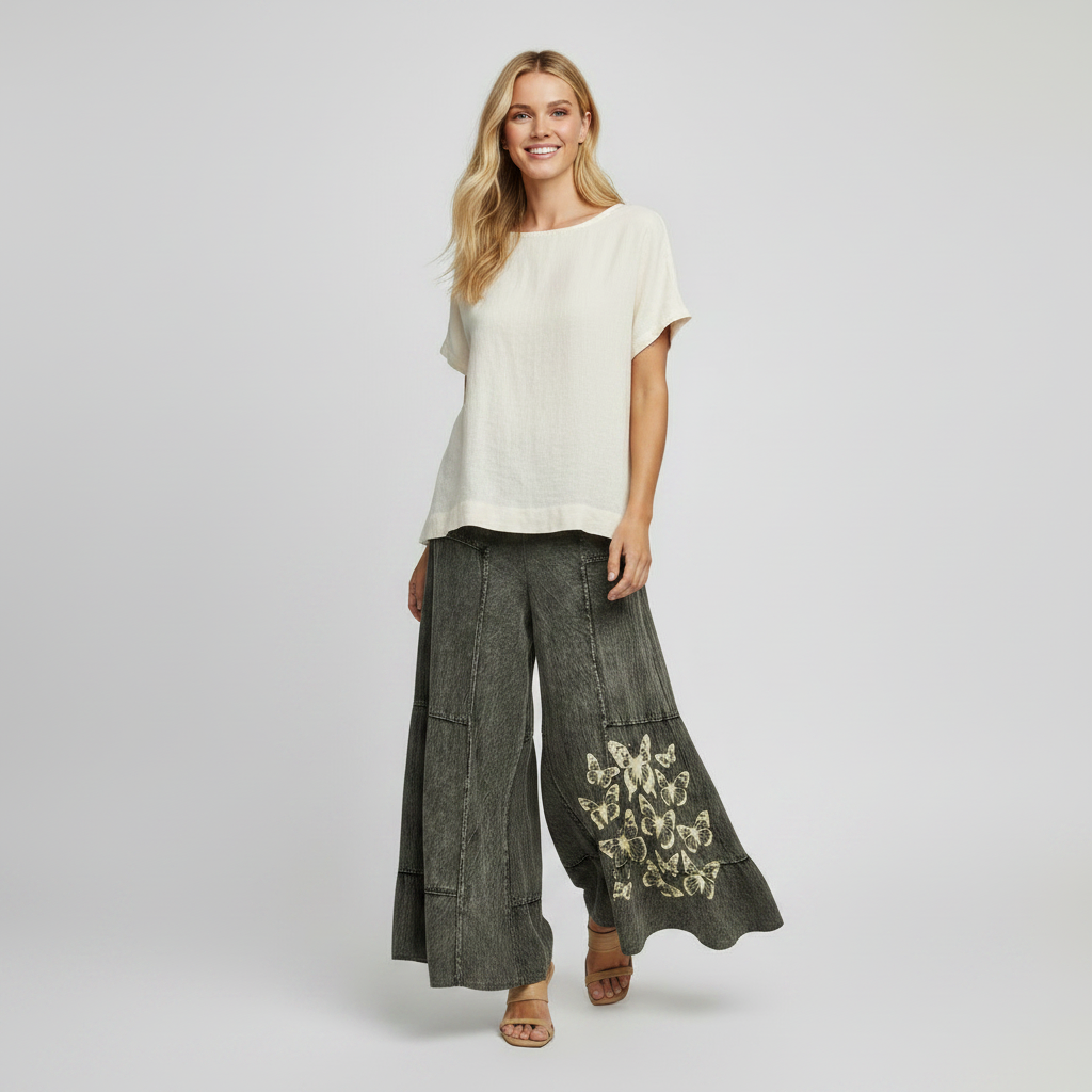 Dark denim pants with butterfly patterns on a light gray background