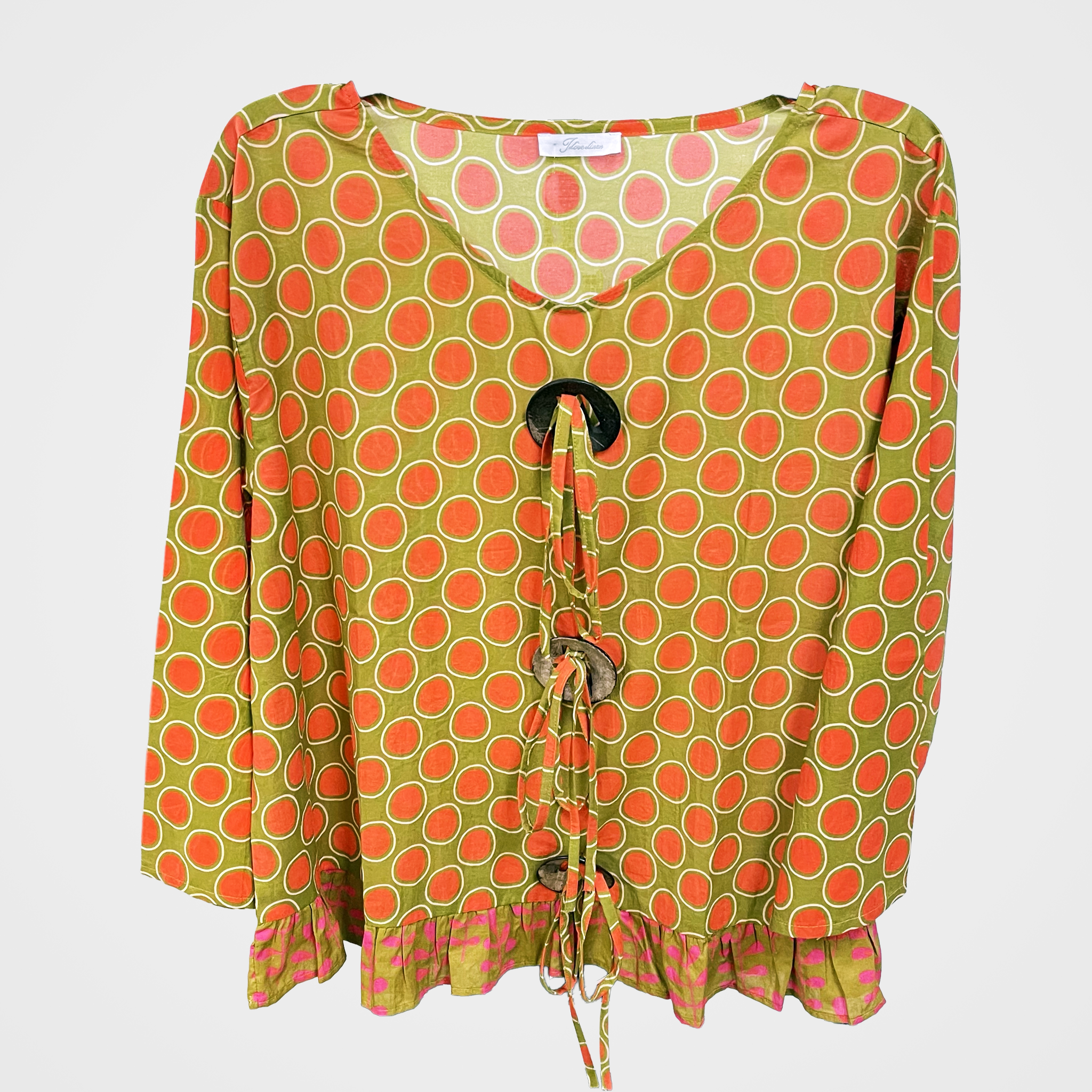 A women's long-sleeve blouse with a green and orange polka dot pattern, featuring a V-neckline, front tie closure with wooden beads, and a ruffled hem.